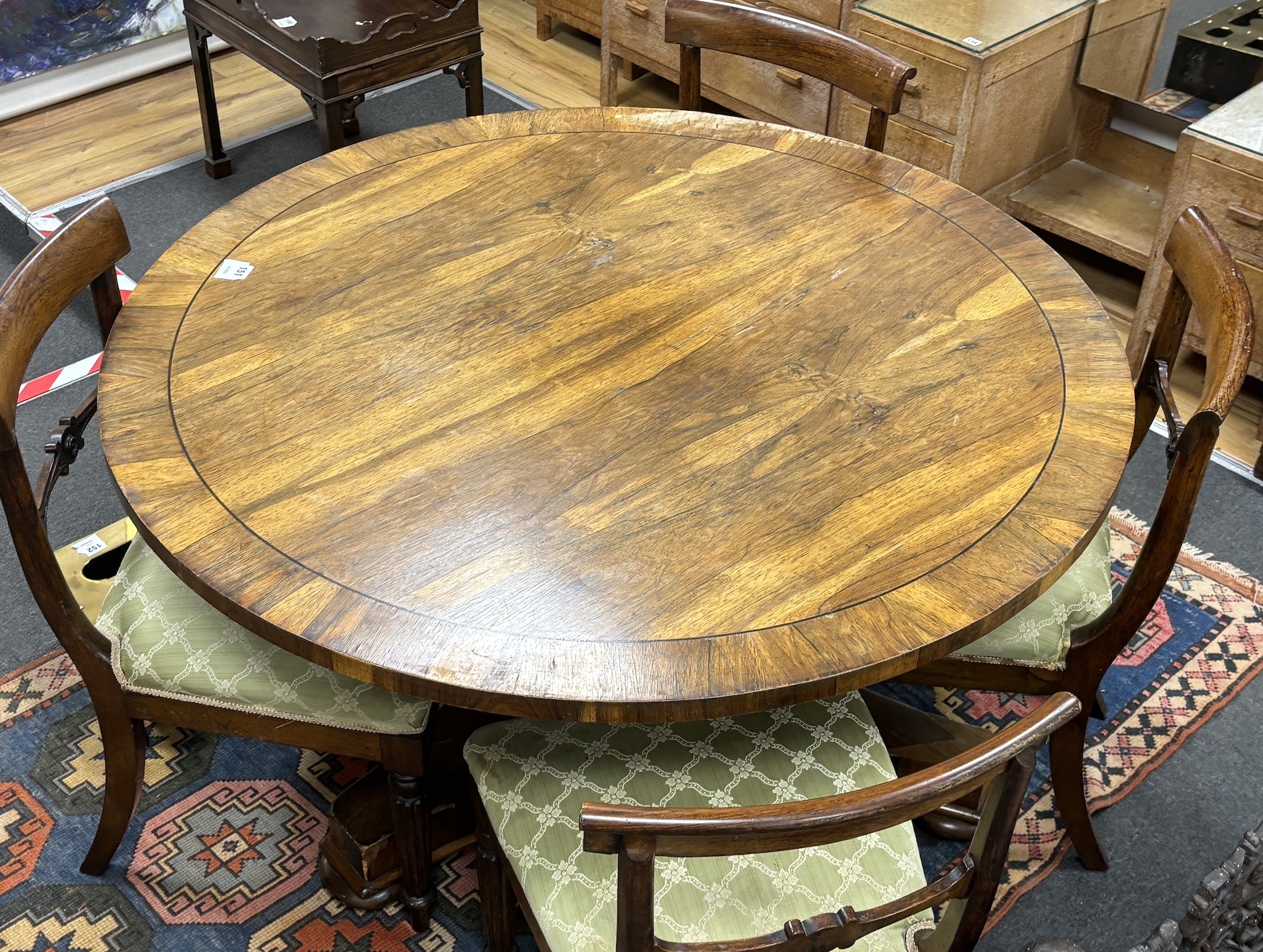 A Regency circular rosewood tilt top breakfast table, diameter 121cm, height 71cm together with four Regency rosewood dining chairs